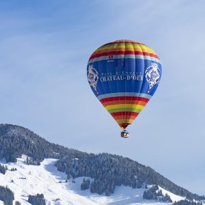 Ballon Château d'Oex au dessus des montagnes enneigées FIBCHAX 2023